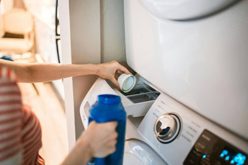 Pouring laundry detergent into the washing machine
